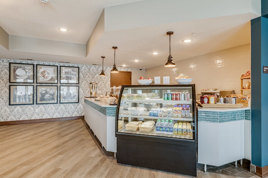 Cafeteria with display case, pendant lights, and framed pictures on the wall.