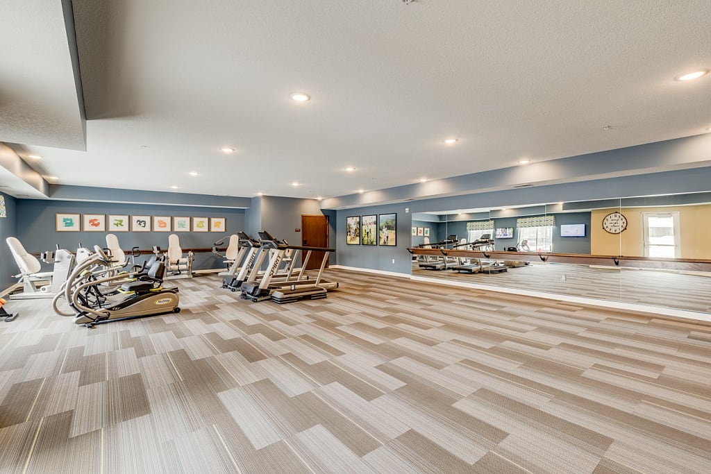 Large exercise room with full length mirrors and various fitness equipment.