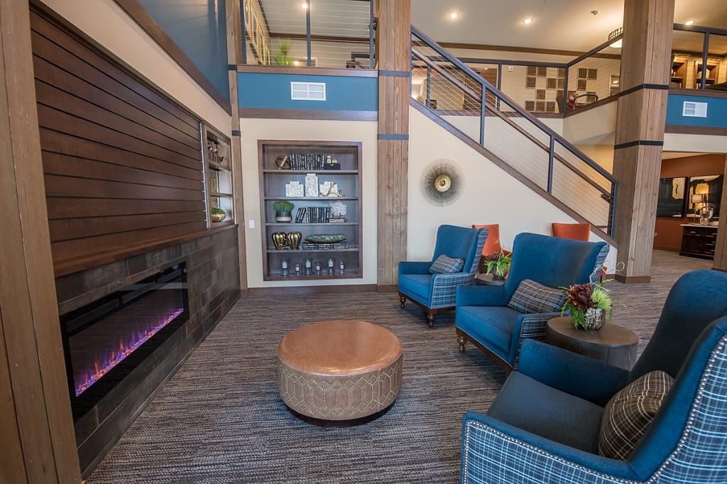 Cozy common area with fireplace, armchairs, and a loft.